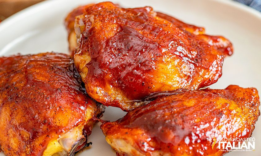 smoked chicken thighs stacked on a plate