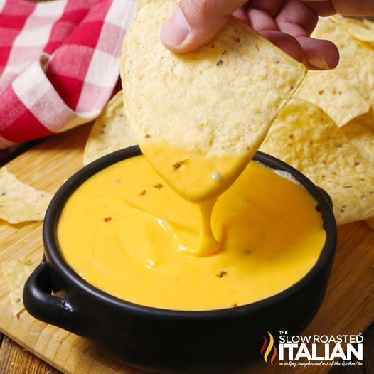 dipping chip into hot creamy cheese sauce