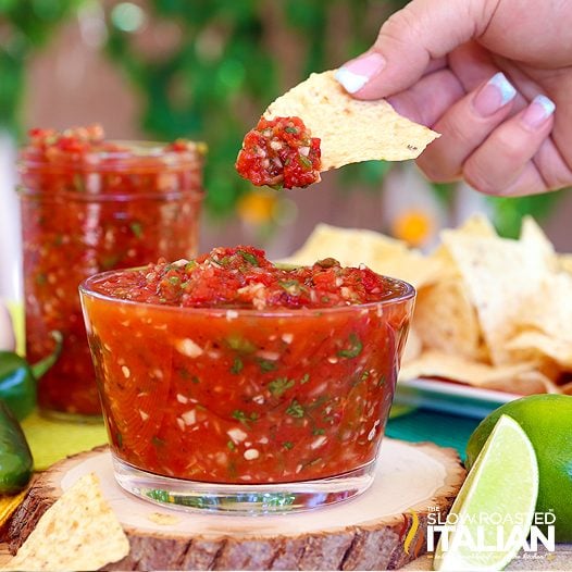 dipping a chip in a bowl of easy blender salsa 