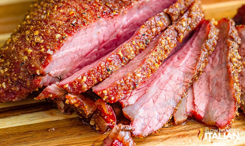 seasoned slices of bbq beef roast on cutting board