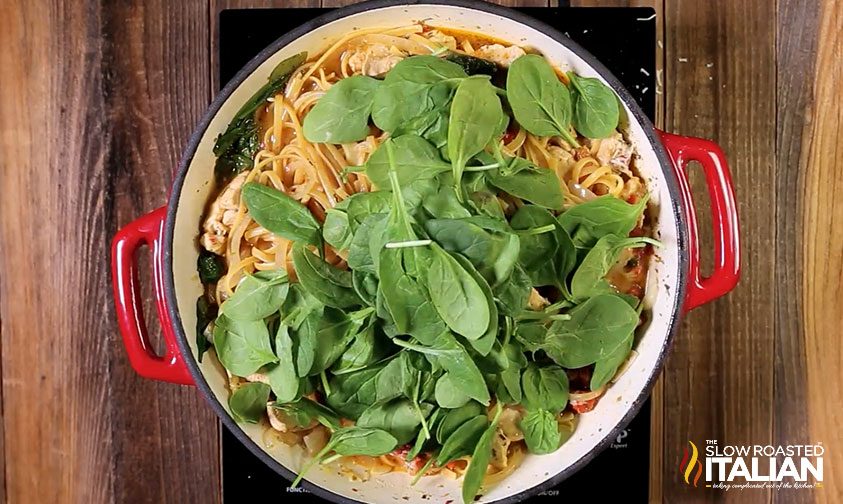 adding fresh baby spinach to one pot cheesy italian pasta and chicken