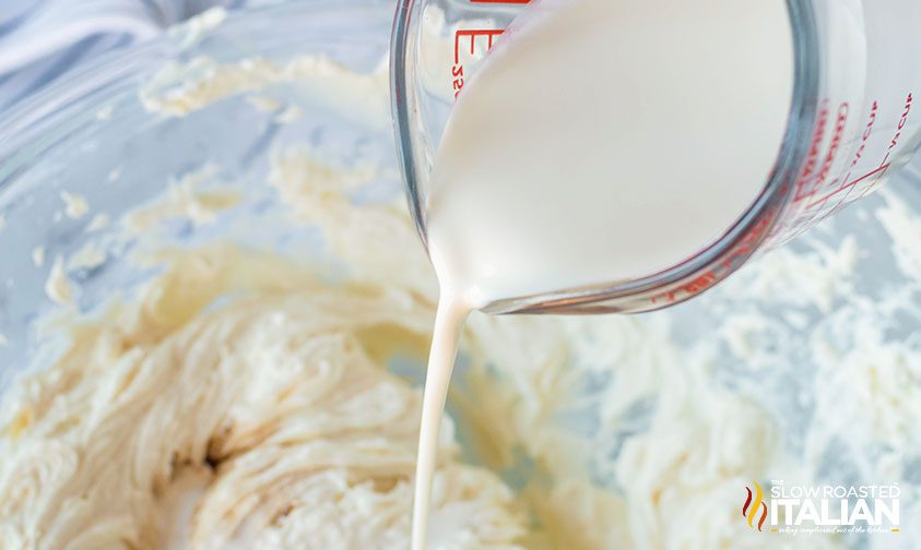 pouring heavy cream into bowl with ingredients