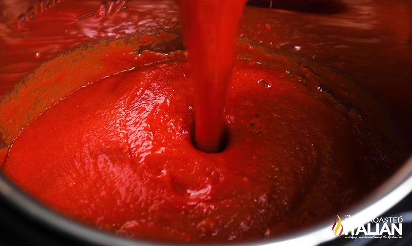 pouring crushed tomatoes into pot