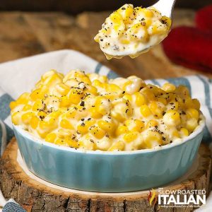 creamed corn with cream cheese on spoon above bowl