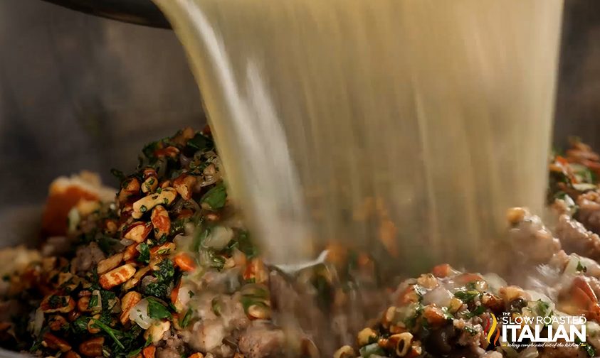 stuffing mixture with chicken stock being poured on it