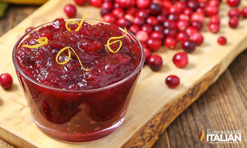 cranberry sauce in glass bowl with cranberries in the background
