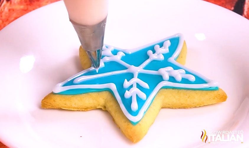 decorating with white icing over the blue icing