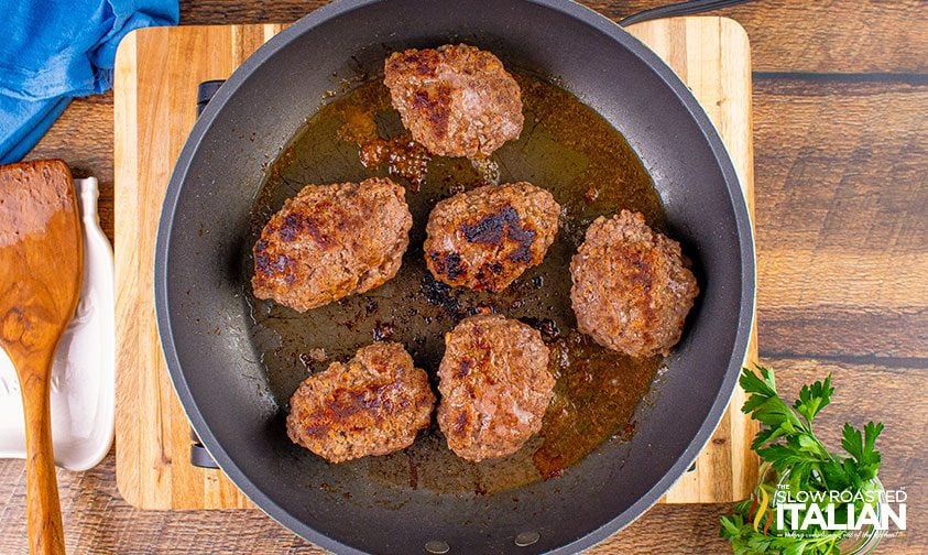 overhead: browned ground beef patties in skillet