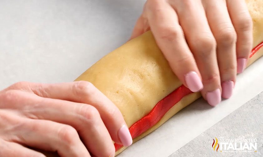 woman's hands rolling dough for pinwheel cookie recipe