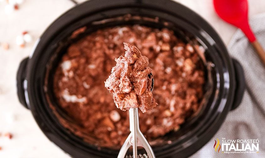 crockpot candy mixture in melon baller over slow cooker