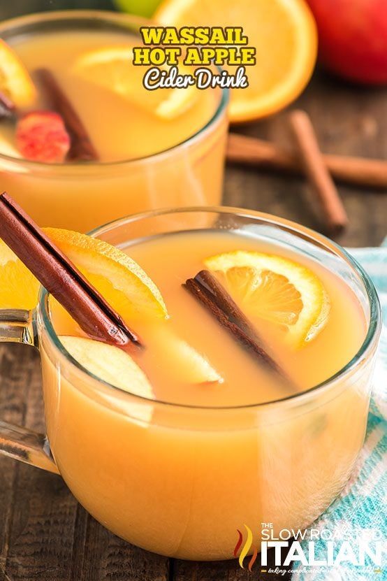 hot apple cider in glass with oranges and cinnamon sticks