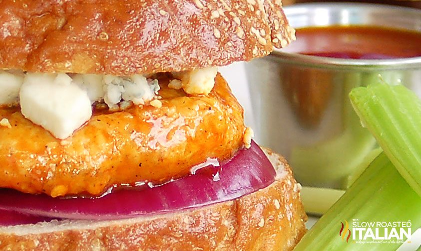 extreme close up: buffalo chicken sandwich on pretzel bun with blue cheese