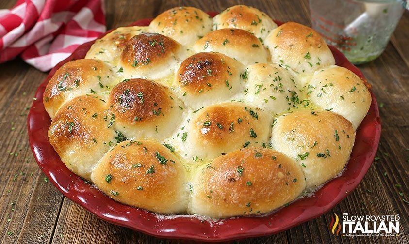 golden baked pull apart bread rolls in red pie dish