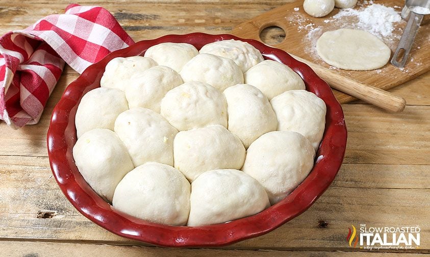 "bombs" of stuffed bread dough in red pie plate, ready for baking