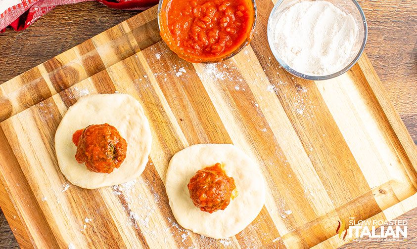 flattened dough with meatball on top