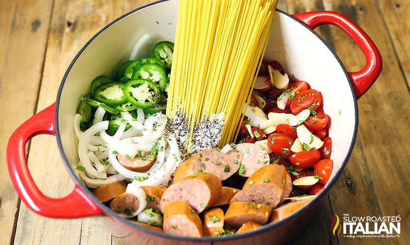 uncooked spaghetti and vegetables in dutch oven