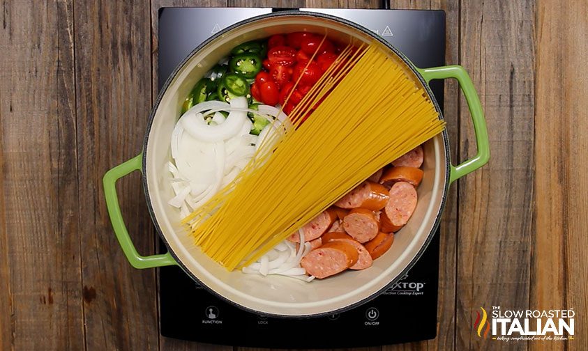 uncooked ingredients in large pot for mexican pasta dinner