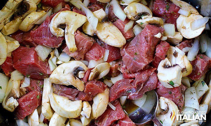 close up photo of uncooked beef sirloin pieces and raw mushroom slices