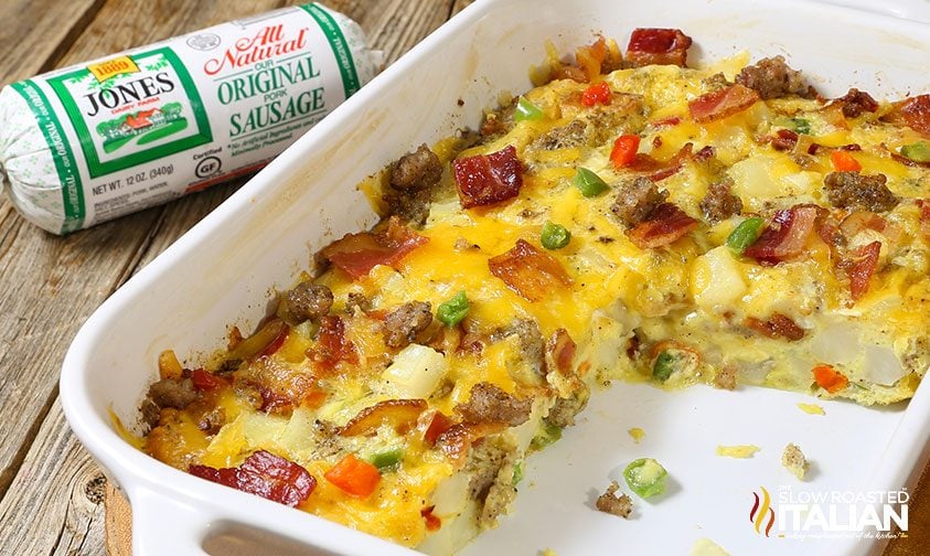 breakfast casserole with bacon, sausage, and cheese in white baking dish