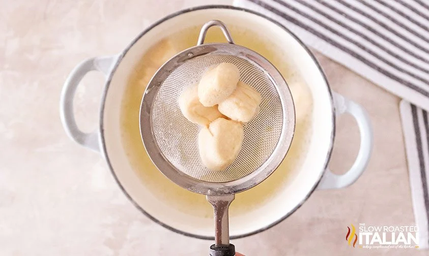 sieve over a pot of pretzel bites