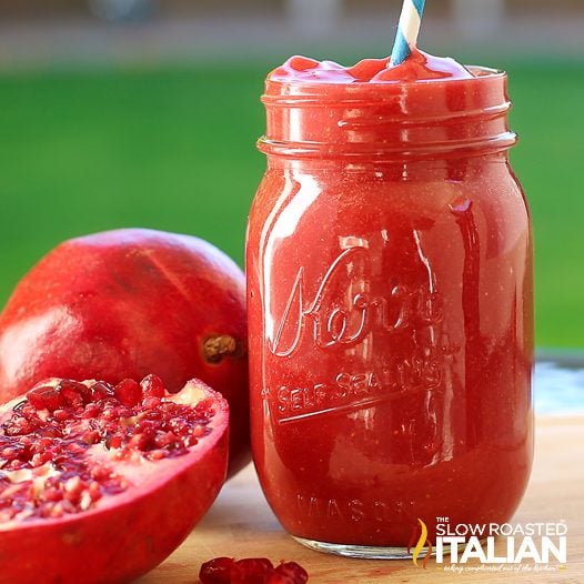 pomegranate smoothie in mason jar glass with straw
