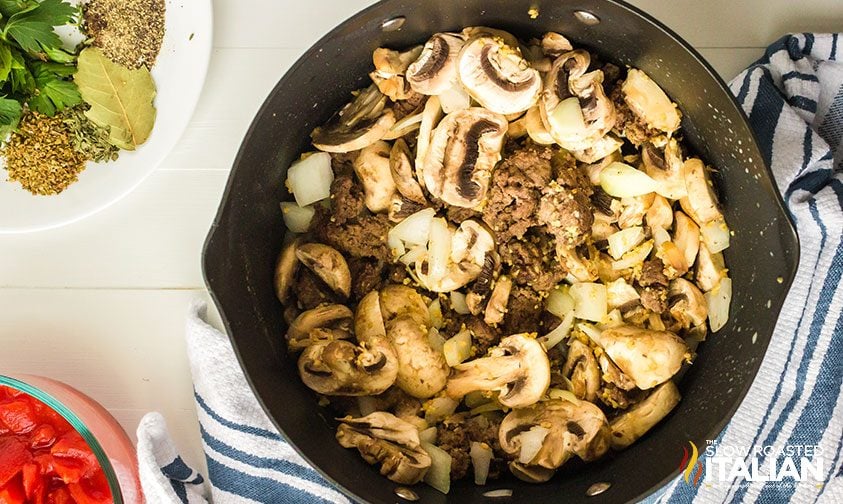 cooking mushrooms and ground beef in saucepan