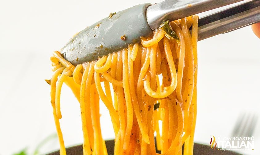 spaghetti noodles in kitchen tongs