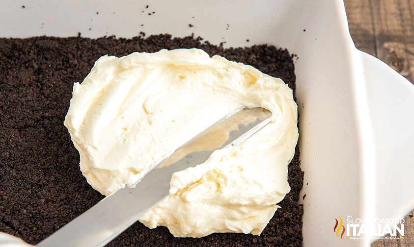 spreading whipped cream layer into chocolate lasagna