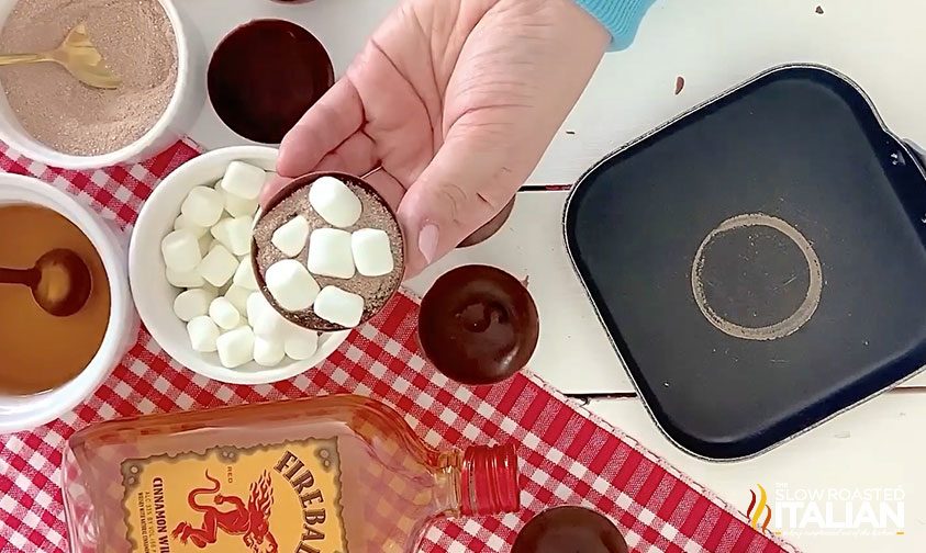 adding marshmallows to chocolate half