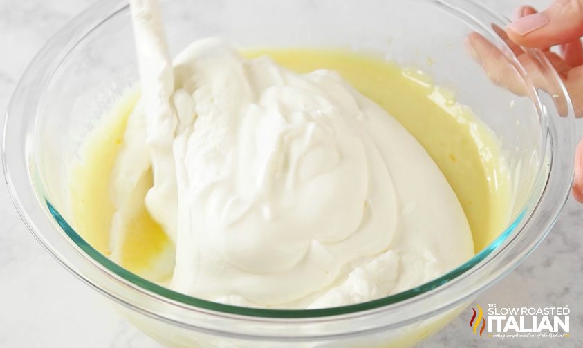 Mixing whipped cream and lemon mixture in a bowl
