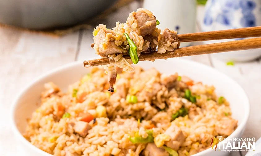 chopsticks holding rice and pork