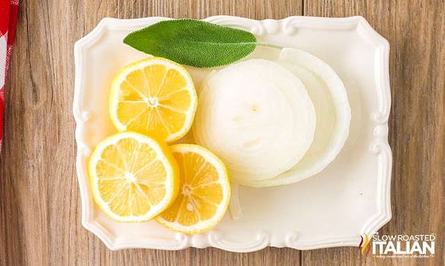 sage, lemon slices and slices of white onion on small white tray