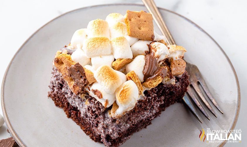 Marshmallow Smores Poke Cake on a plate with fork