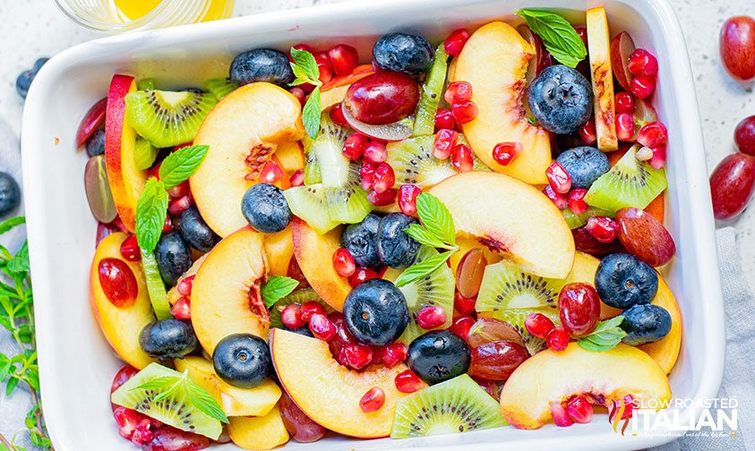 colorful fruit salad in a white serving dish