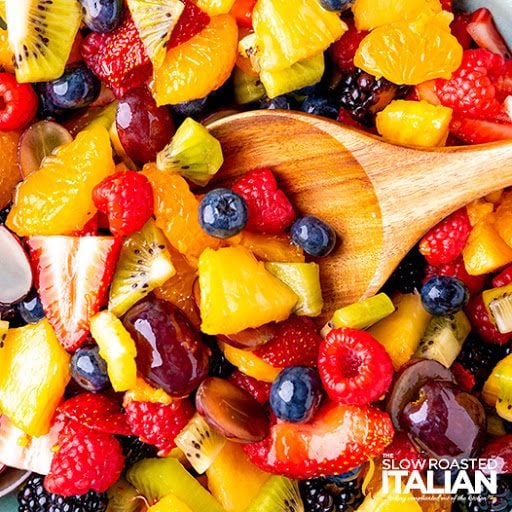 wooden spoon in summer fruit salad, close up