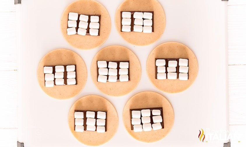 chocolate and mini marshmallows in the center of small pie dough rounds