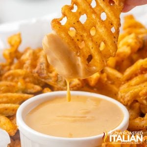 dipping waffle fries into chick fil a sauce