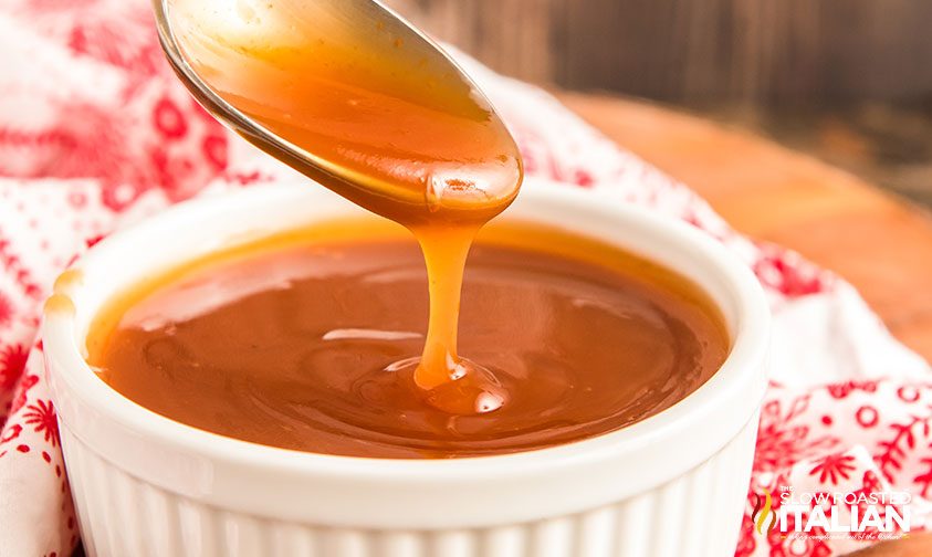homemade sweet and sour sauce pouring off spoon into ramekin