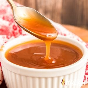 sweet and sour sauce on spoon above white ramekin