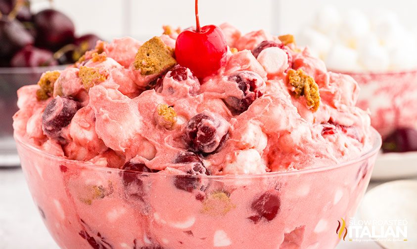 bowl of cheesecake salad with cherries and graham crackers