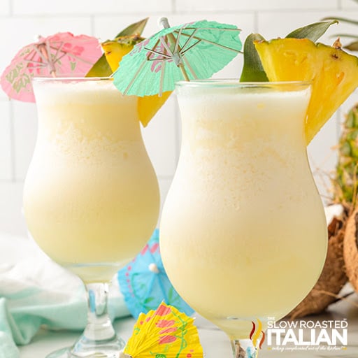 2 pina colada cocktails in tall glasses with umbrellas