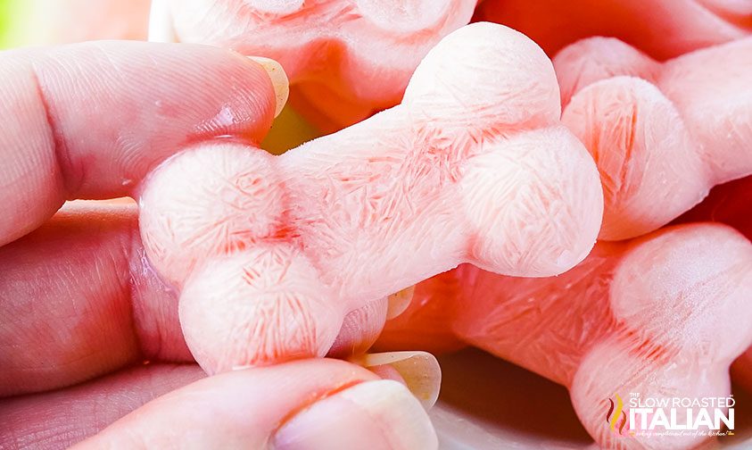 frozen dog treats being held up by a woman\'s hand