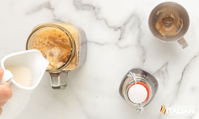 adding cream to iced cinnamon dolce latte