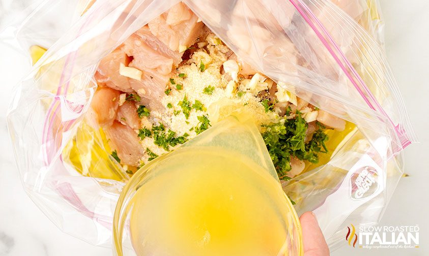 adding lemon chicken marinade to zip top bag for chicken bites recipe