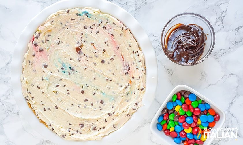 no bake cheesecake next to bowls of toppings to be added