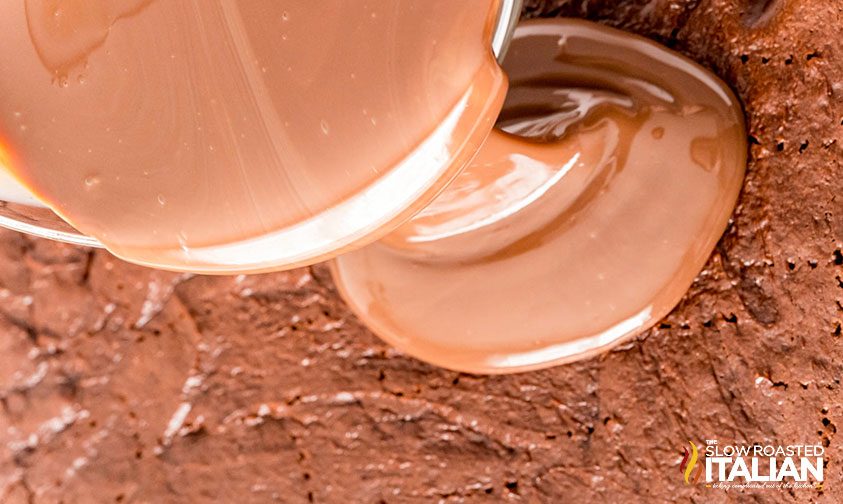 pouring condensed milk over poke cake
