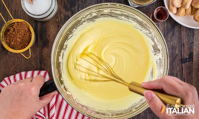 whisking ingredients in bowl for classic Italian dessert