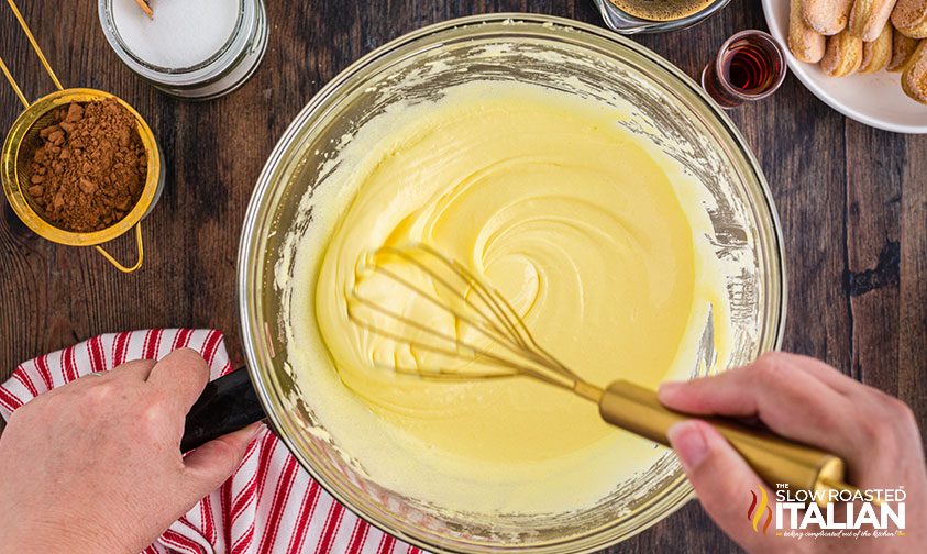 whisking ingredients in bowl for classic Italian dessert