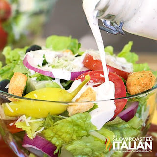 pouring dressing on bowl of salad
