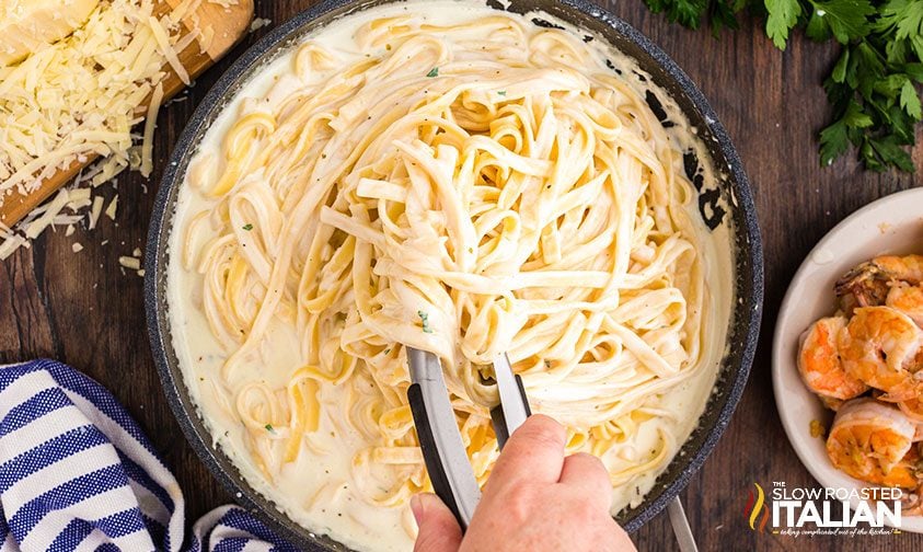 shrimp alfredo with pasta in a skillet
